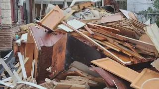 Neighbors fight to clean up junk pile outside vacant home