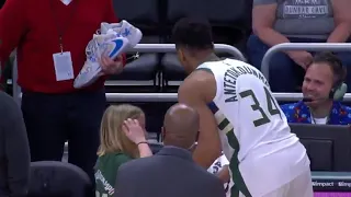 Giannis gives a young fan his shoes after the game.