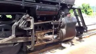 Steam engine pulling train out of station (close up)