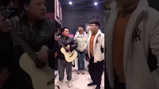 Chinese pinching finger with hammer and playing guitar. Hammering wall