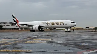 Emirates Boeing B777-300ER departing from a rainy airport back to Dubai