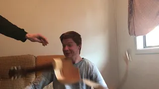 SMASHING A GUITAR OVER HIS HEAD