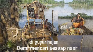 Rela mencari barang bekas di sungai demi kelangsungan hidup//di guyur hujan deras.