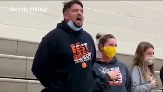 Father stands up to sing national anthem