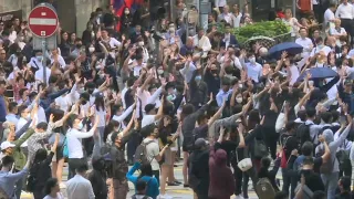 Office workers in HK's business district show solidarity to protest movement | AFP