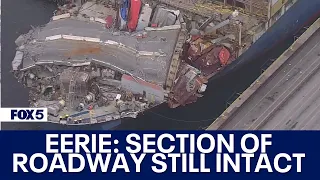 Baltimore Key Bridge collapse: Section of roadway that fell remains unbroken across container ship