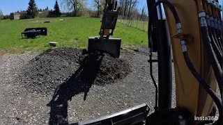 Working on old parking lot using excavator to spread crushed stone
