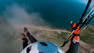 Paragliding in and out of coastal clouds.