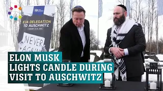 Elon Musk lights candle during visit to Auschwitz-Birkenau