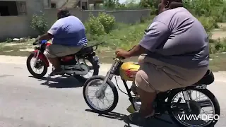 2 fat men racing on low cc motorcycles
