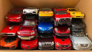 Box full of Alloy model Cars, Tesla, Mazda, Tuntra, Porsche, Defender, Lamborghini, Nissan.