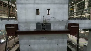 Low-damage concrete building earthquake test: Isolated wall-to-floor connection
