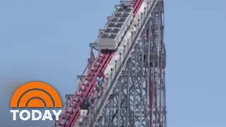 Riders climb down safely after roller coaster stops near the top