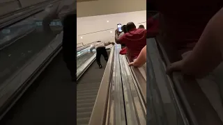 Man Runs up Downward Traveling Escalator as Strangers Cheer Him on