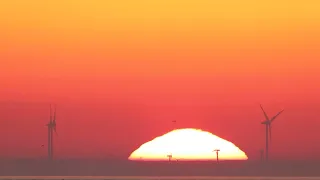 Am Strand bei Cuxhaven: Der rote Feuerball steigt aus der Nordsee auf