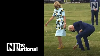 President Biden picks a dandelion for the first lady as they leave the White House