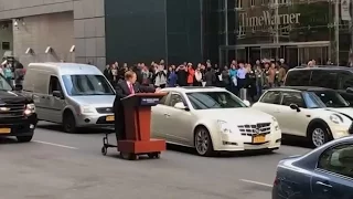 Melissa McCarthy, as Sean Spicer, drives podium through NYC streets