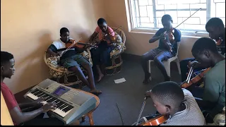 Because he live- Joseph Sseguya directing the Mbarara community music school young violinists