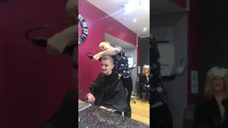 Girl with buzzcut giving same haircut to her friend