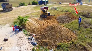 Busy teamworking start project by Komatsu Dozer with dump trucks unloading delete the grass