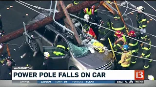 Power pole falls on car