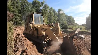 Cutting a mountain road Cat 943 track loader