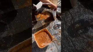 Palestinian girl in Gaza scoops up spilt food