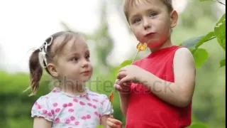 little pretty girl and boy lick lollipops in summer park