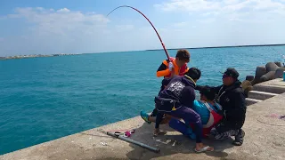 four people catch a huge fish