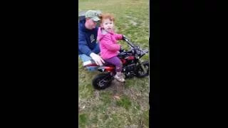 Little girls trying on the new dirt bike.