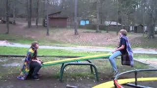 Two red necks on a seesaw wearing blankets as capes