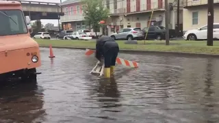 Woman tries to slow cars driving through flooded streets