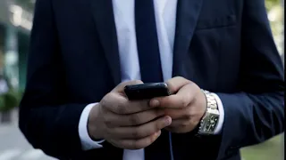 close up of mans hands holding modern smartphone businessman walking while typing on