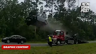 Speeding car flies through the air after launching off tow truck ramp on highway in wild video