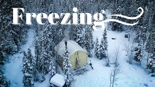 WINTER STRIKES TENT IN FROZEN FOREST.  WOOD STOVE, SNOW, SALMON