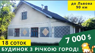 Oгляд будинка в селі з річкою в городі