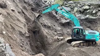 Sand cliff collapses as excavator digs through sand