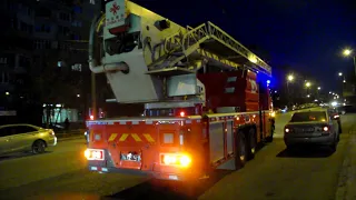 Aerial ladder platform + fire engine with blue lights returns to station