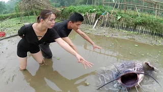 The girl pumps water from the pond to catch fish and the boy goes down to help the girl catch fish