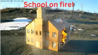Cardboard school building burning down.