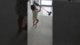 Baby mimick housechores with Dyson vacuum toy