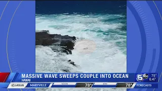Massive wave sweeps couple into ocean on Hawaii beach