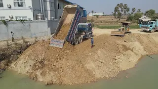 Fantastic bulldozer and dump truck make road along river