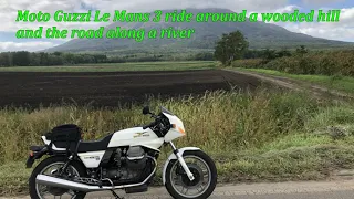 Moto Guzzi Le Mans 3 ride around a wooded hill and the road along a river