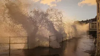 A wave hits St Ives Cornwall seafront at dawn 2023