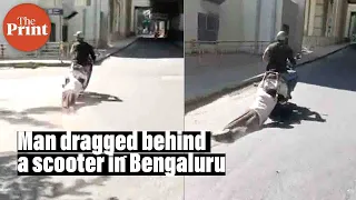 Man being dragged behind a scooter on Bengaluru's Magadi road