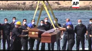 Coffins of victims of last week's tragedy lifted onto navy ship