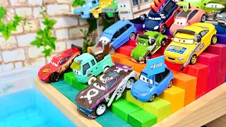 Cars miniature cars fall into the water as they roll down a colorful rainbow-colored stair slope！