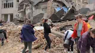 Volunteers in Kyiv help to clear rubble from streets after latest Russian missile strikes