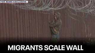 Caught on camera: Migrants dressed in camo scale Arizona border wall